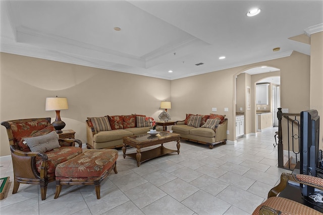 living room with crown molding, light tile patterned flooring, and a tray ceiling