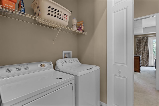 clothes washing area featuring washing machine and clothes dryer and light colored carpet