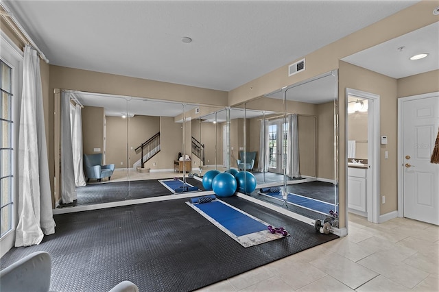 workout room featuring light tile patterned floors