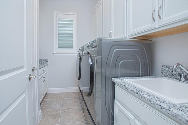 laundry area with cabinets, independent washer and dryer, sink, and light tile patterned floors