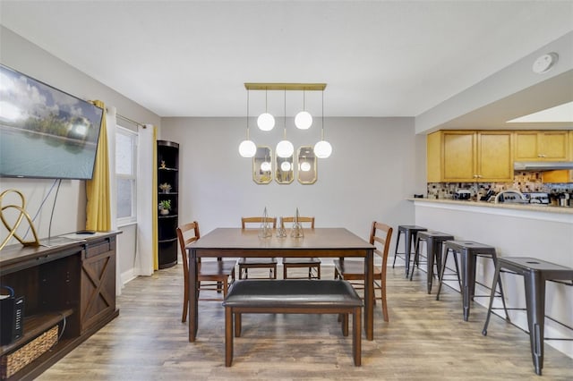 dining room with a notable chandelier and light wood-type flooring