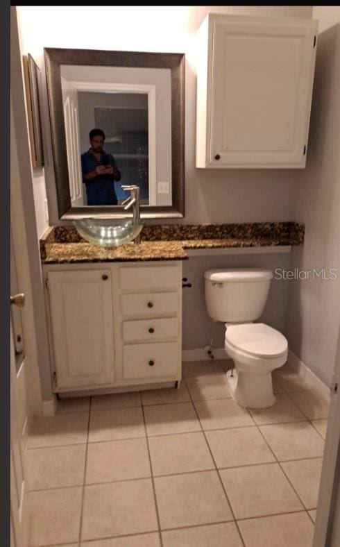 bathroom featuring tile patterned flooring, vanity, and toilet