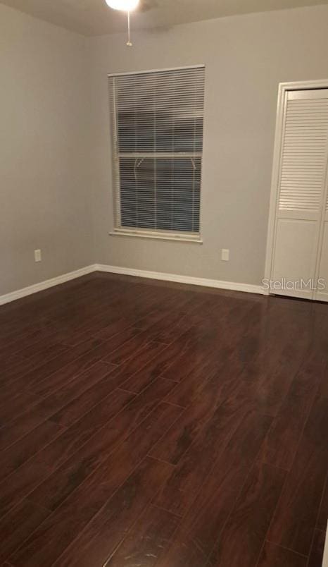 empty room with dark hardwood / wood-style flooring