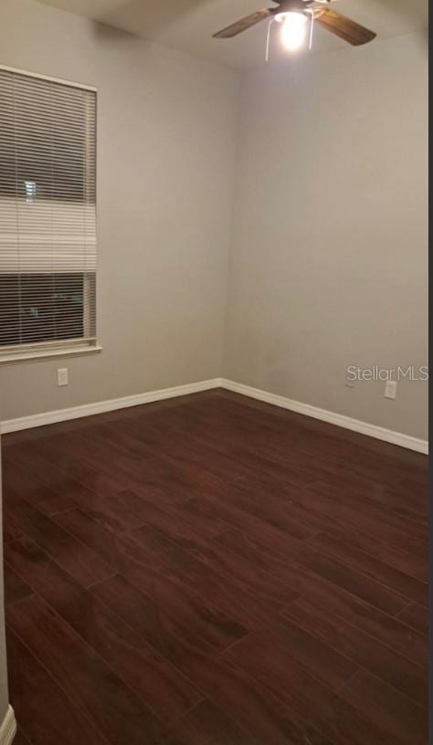 spare room with dark hardwood / wood-style flooring and ceiling fan