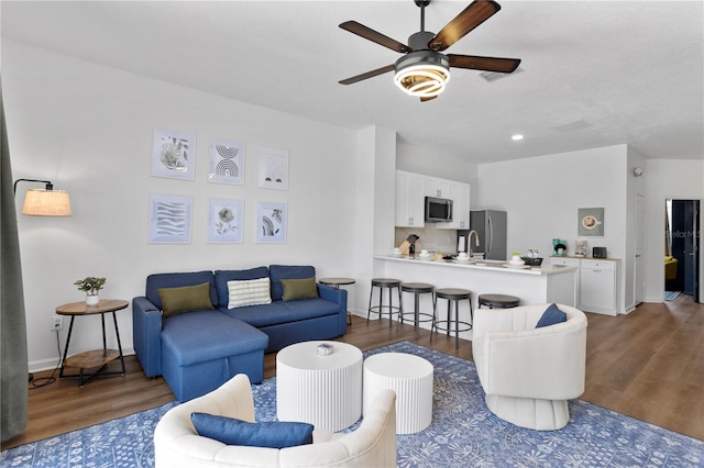 living room with ceiling fan and dark hardwood / wood-style flooring