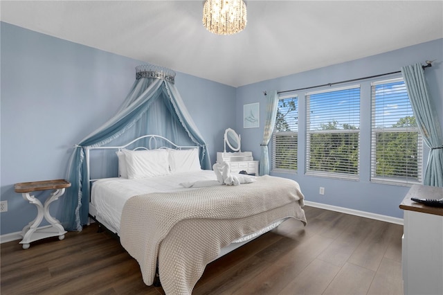 bedroom featuring dark wood-type flooring and an inviting chandelier