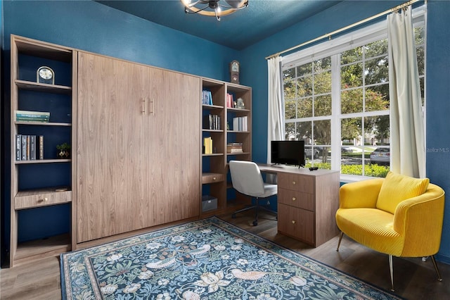 office area with wood finished floors and built in desk