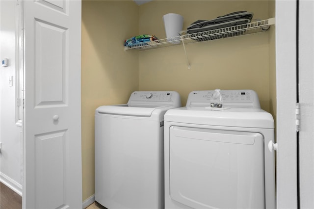 clothes washing area with separate washer and dryer