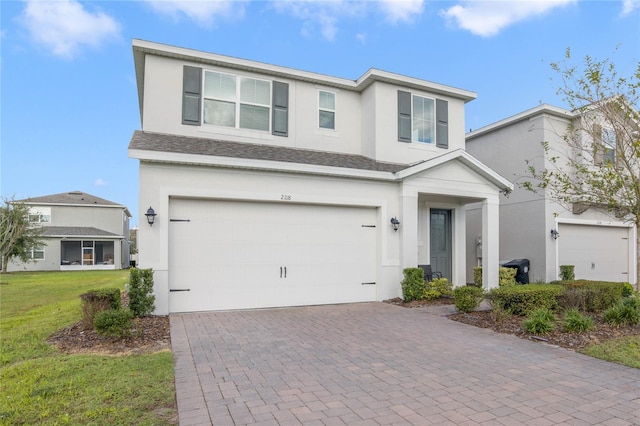 view of property featuring a front yard and a garage