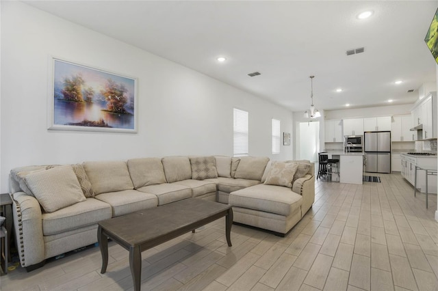 living room featuring light hardwood / wood-style flooring and a notable chandelier