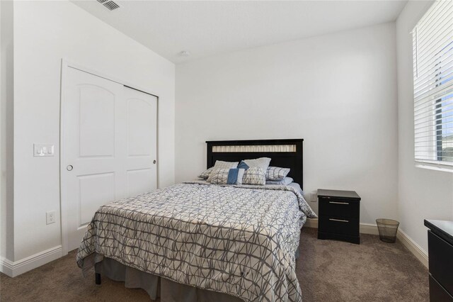 bedroom featuring a closet and dark carpet