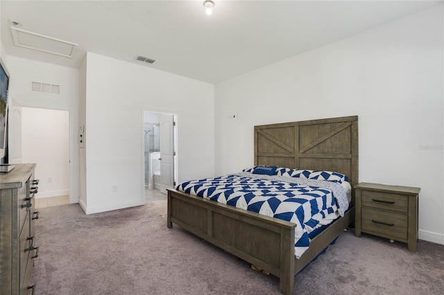 bedroom with ensuite bathroom and carpet floors