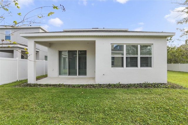 rear view of property featuring a patio area and a lawn