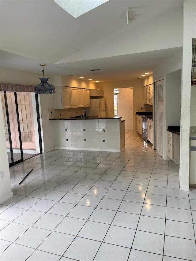 interior space featuring sink, a skylight, and light tile patterned floors