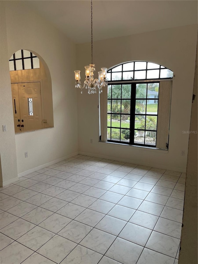 unfurnished room featuring light tile patterned flooring and an inviting chandelier