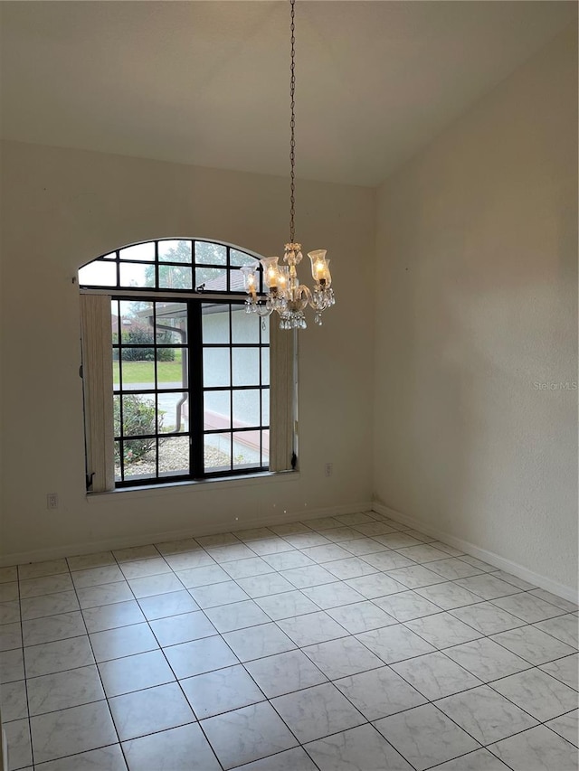 unfurnished room with a chandelier and light tile patterned floors