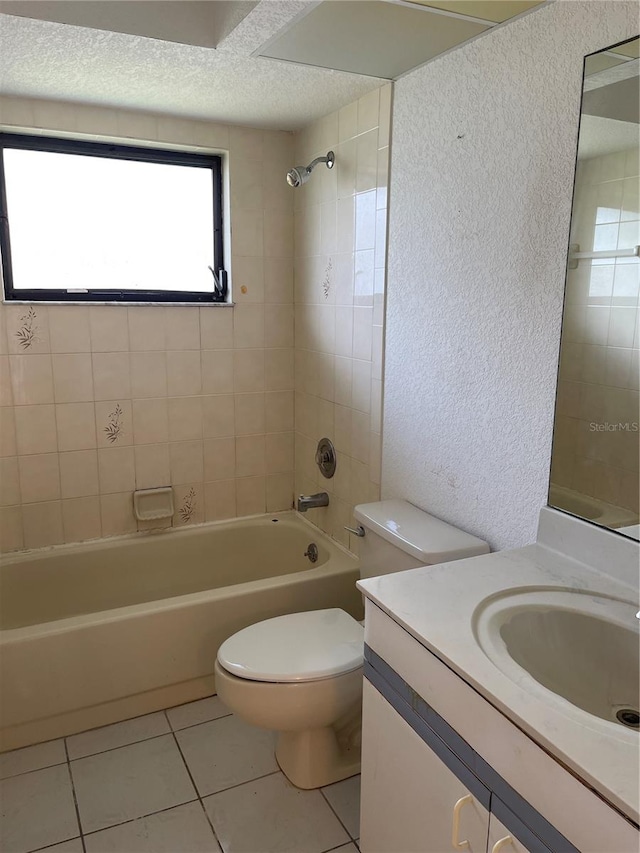 full bathroom with vanity, tiled shower / bath, toilet, and tile patterned flooring