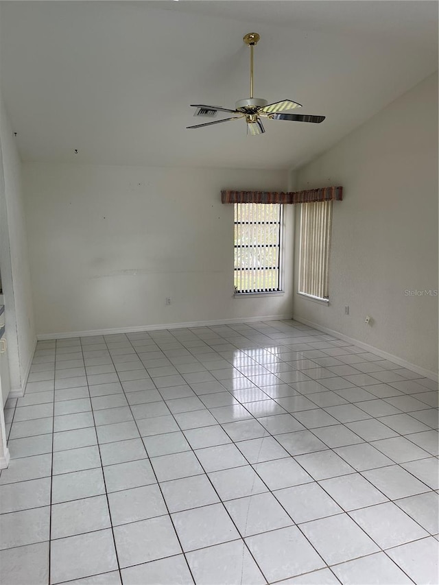 spare room with ceiling fan and light tile patterned floors