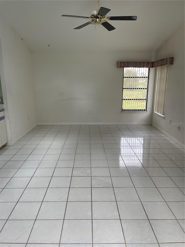 spare room with ceiling fan and light tile patterned flooring