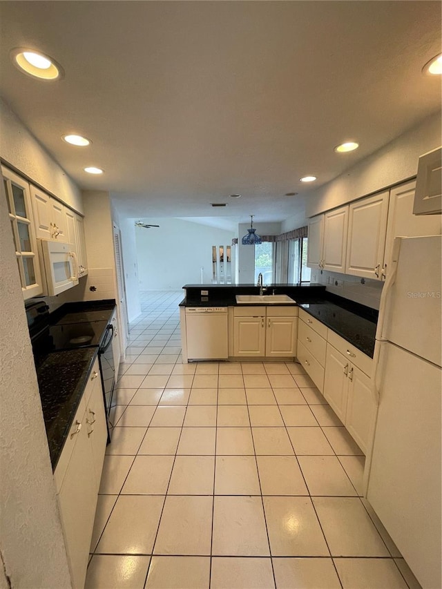 kitchen featuring kitchen peninsula, white cabinets, light tile patterned floors, sink, and white appliances