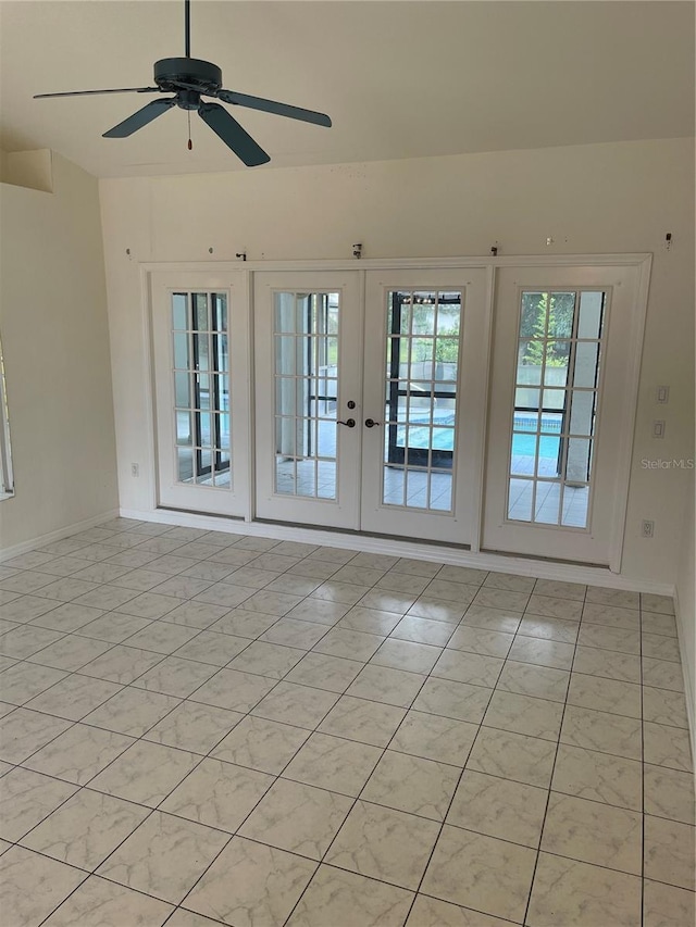 tiled spare room featuring french doors and ceiling fan