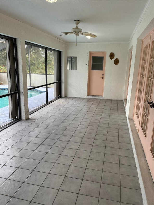 unfurnished sunroom with ceiling fan