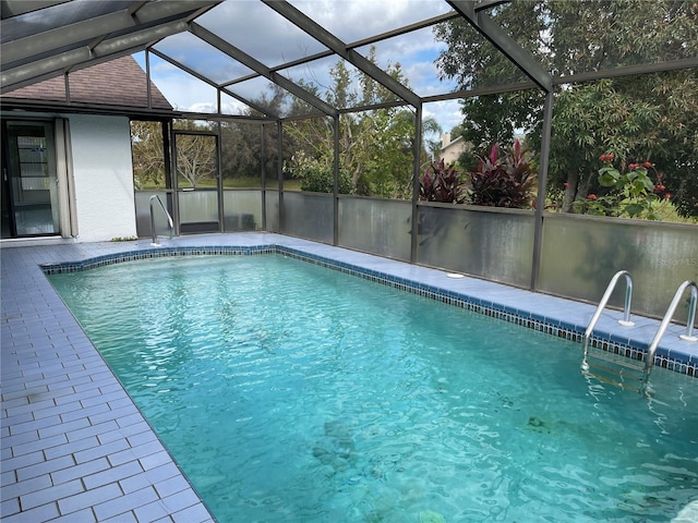 view of swimming pool featuring a patio and a lanai