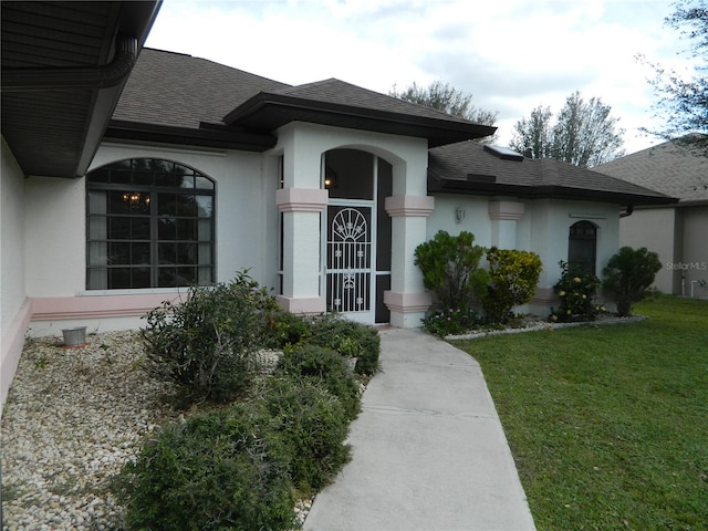 view of exterior entry featuring a lawn