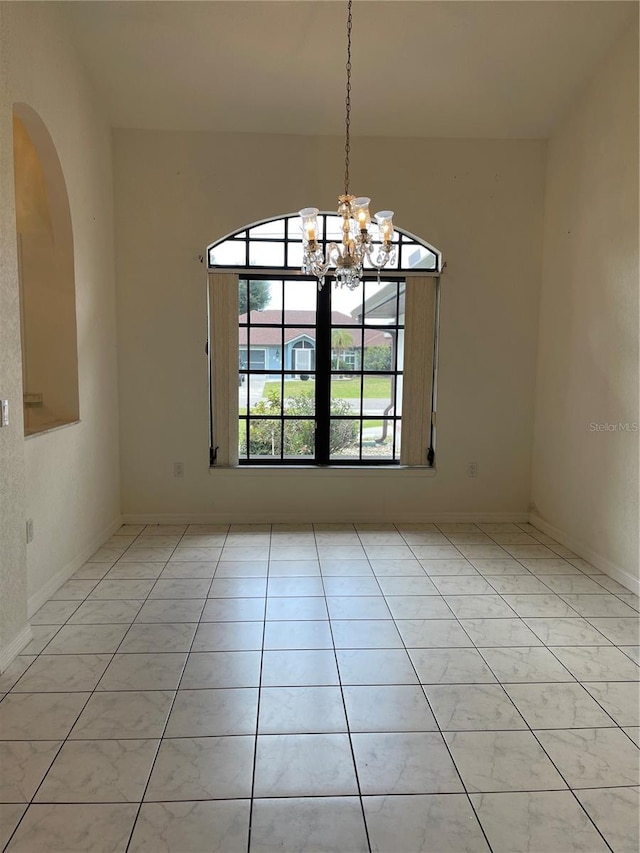 unfurnished dining area featuring an inviting chandelier and light tile patterned floors