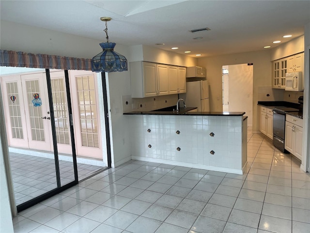 kitchen featuring white appliances, backsplash, kitchen peninsula, white cabinetry, and decorative light fixtures