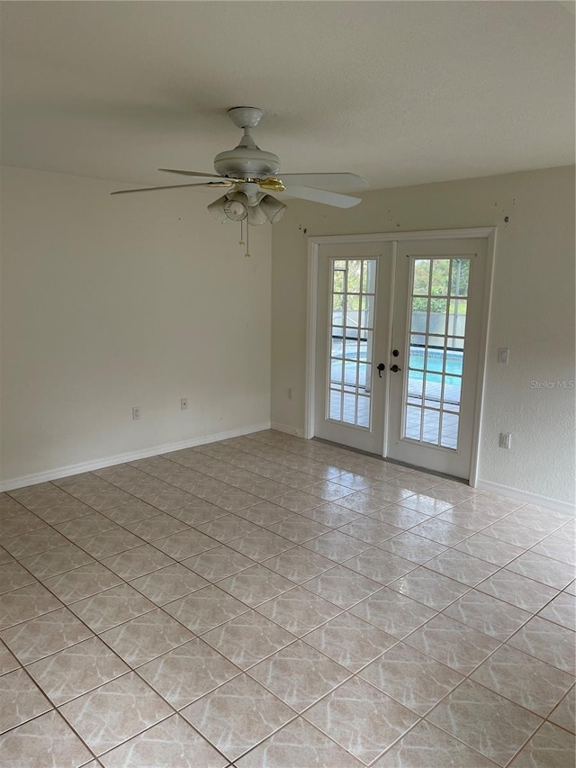 empty room featuring french doors, light tile patterned floors, and ceiling fan