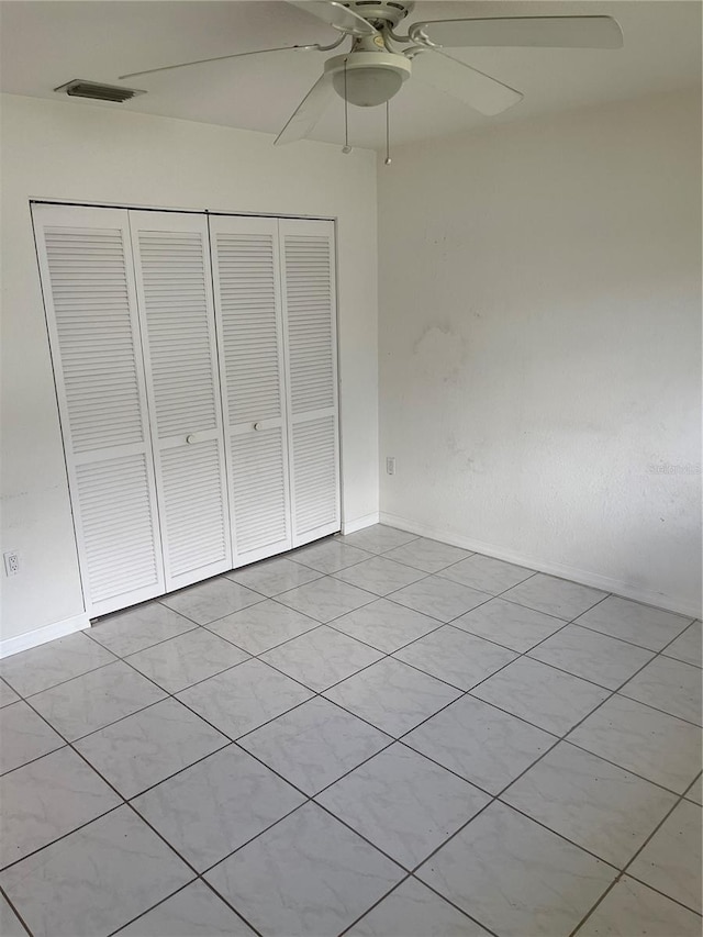 unfurnished bedroom featuring a closet, ceiling fan, and light tile patterned floors