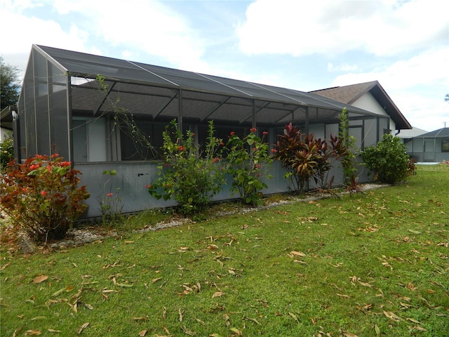 view of side of property with a yard and glass enclosure