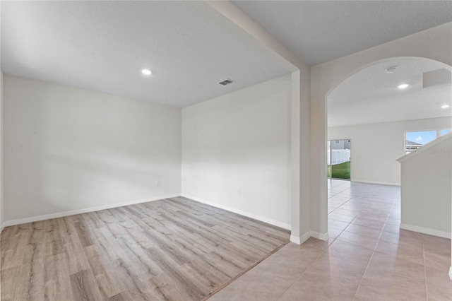 unfurnished room with light hardwood / wood-style floors and a textured ceiling