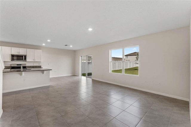 unfurnished living room featuring sink and light tile patterned floors