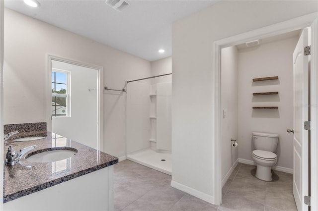 bathroom with vanity, toilet, tile patterned flooring, and a shower