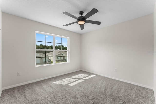 carpeted spare room featuring ceiling fan and a textured ceiling