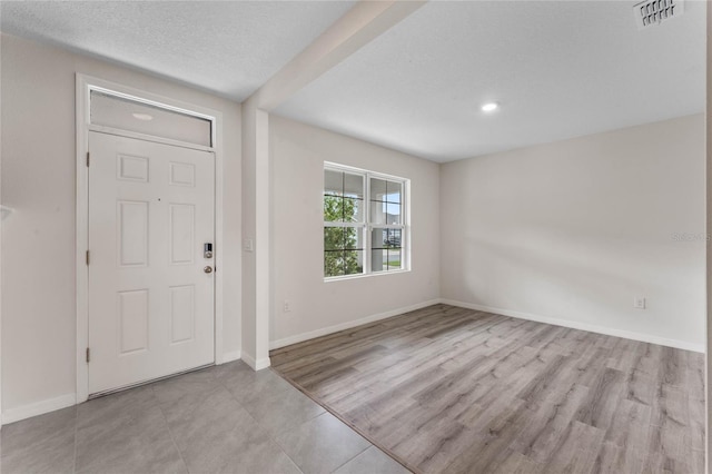 entryway featuring a textured ceiling and light hardwood / wood-style flooring