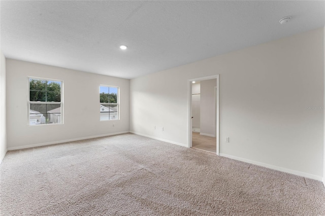 carpeted empty room with a textured ceiling