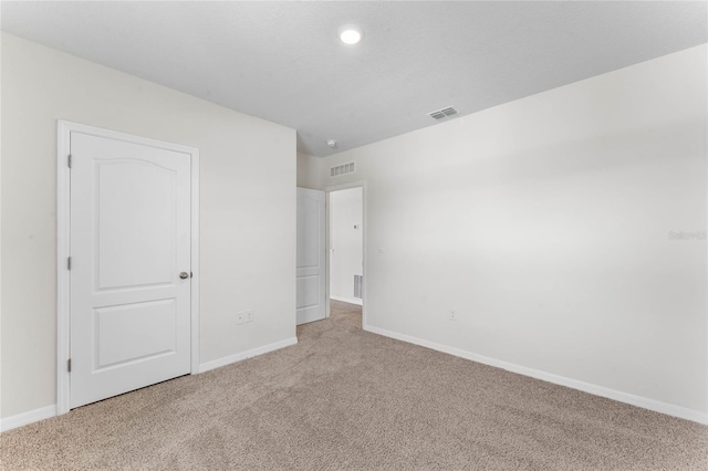 unfurnished bedroom featuring light carpet and a textured ceiling