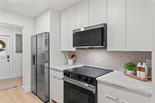 kitchen with white cabinets, stainless steel appliances, and light wood-type flooring