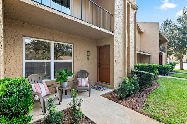 view of exterior entry featuring a balcony