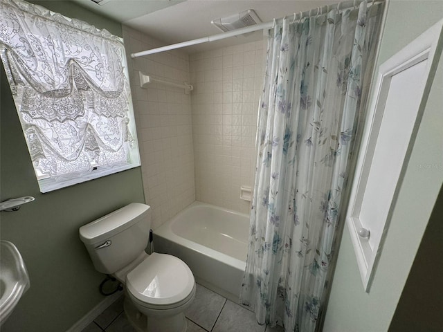 bathroom with tile patterned floors, shower / bath combo with shower curtain, and toilet