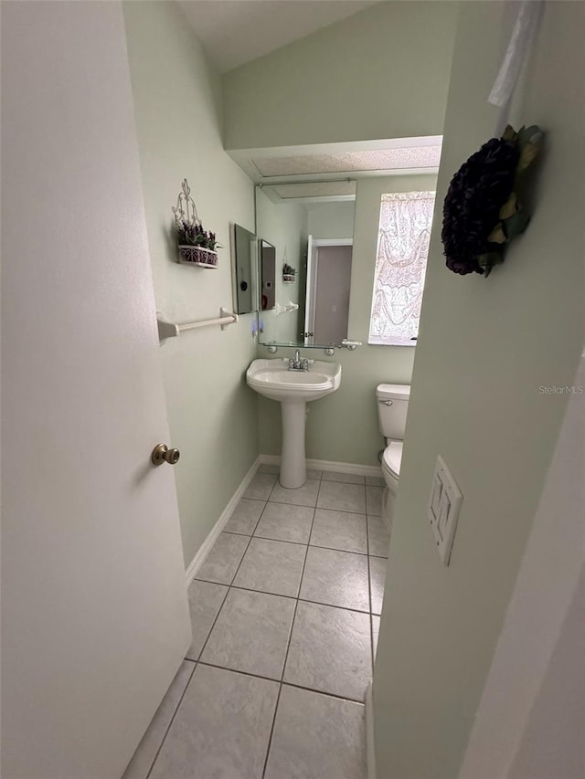 bathroom with tile patterned floors, toilet, and lofted ceiling