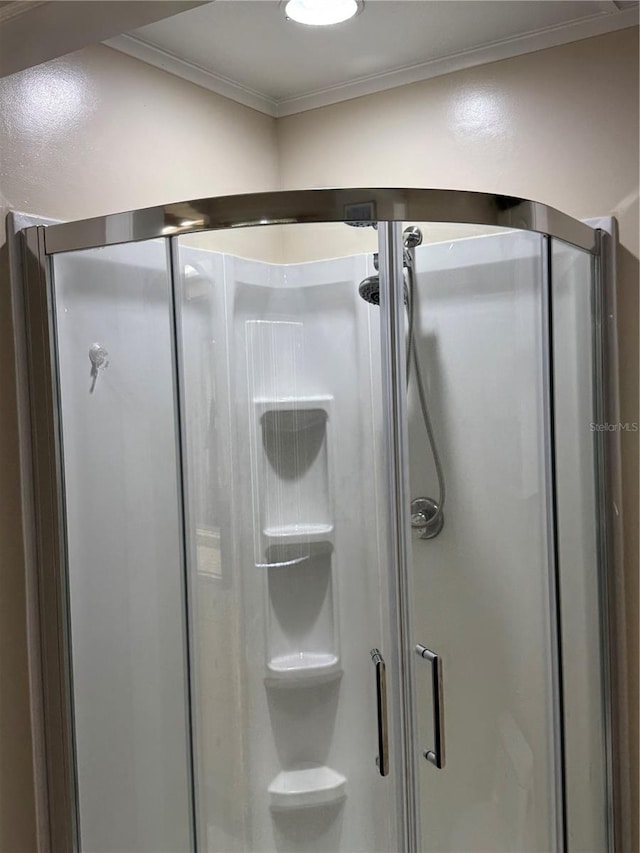 bathroom with an enclosed shower and crown molding