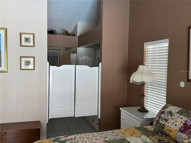 bedroom with dark tile patterned flooring and a closet