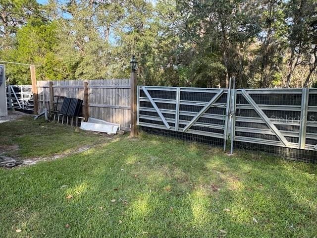 view of gate with a yard