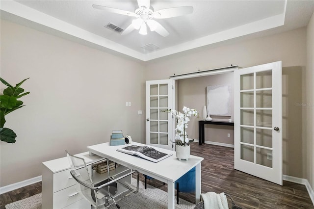 office featuring french doors, ceiling fan, a tray ceiling, and dark hardwood / wood-style flooring