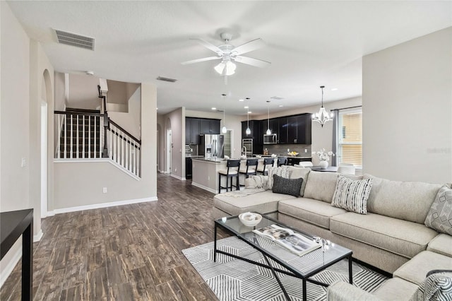 living room featuring dark hardwood / wood-style floors and ceiling fan with notable chandelier