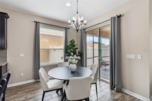 dining area with a notable chandelier and dark hardwood / wood-style flooring